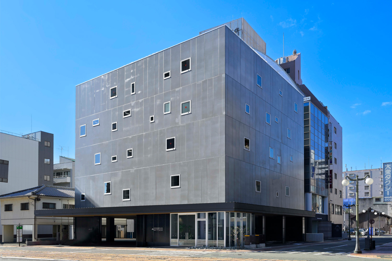 1961年の創業以来、三菱昇降機の代理店・協力会社として、熊本県下一円に三菱エレベーター・エスカレーター・リフト等昇降機設備の販売・設計・施工を行っている出田電業設備株式会社。2025年に竣工した新社屋は、スクエアなフォルムが際立つデザイン性豊かな建物が特徴となっている