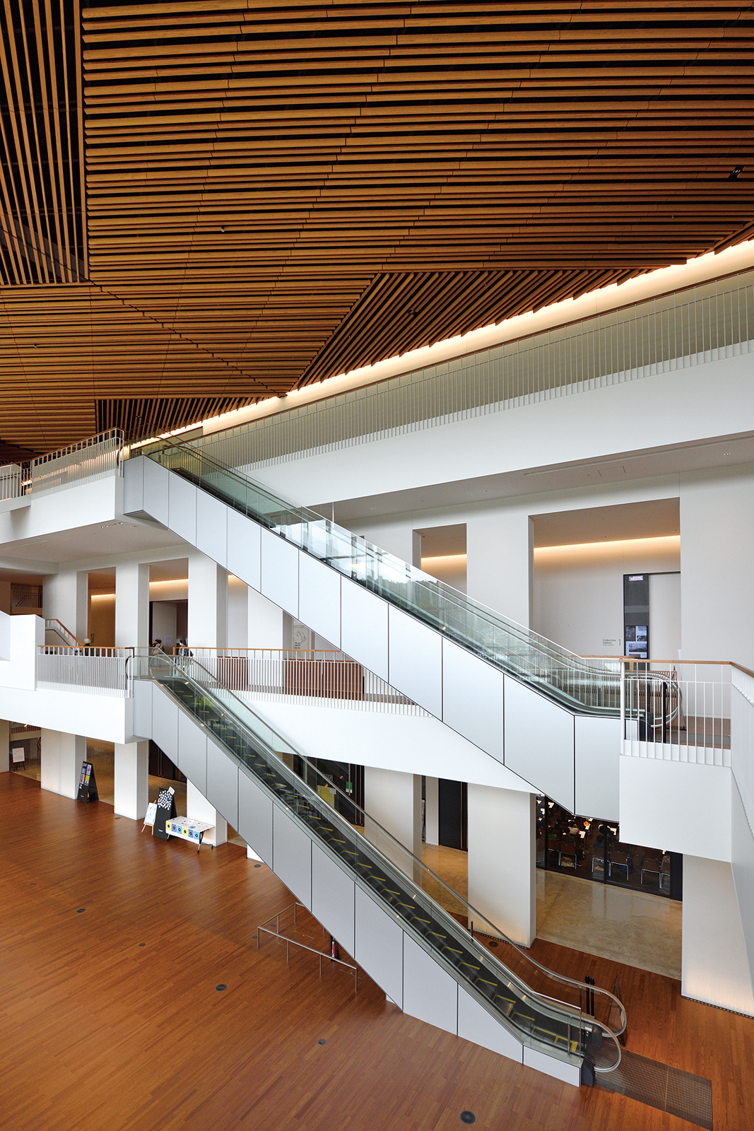 1階～3階の吹き抜け空間をつなぐ2台のエスカレーター。天井は砂丘の風紋や県の特産品である倉吉絣の織文様をイメージし県産の杉材を使用